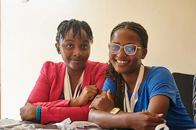 Two attendees smiling at DjangoCon Africa 2023
